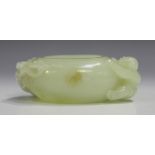 A Chinese pale celadon jade brushwasher, probably 20th century or later, the oval body carved in