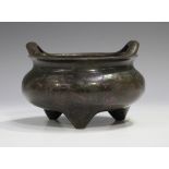 A Chinese brown patinated bronze tripod censer, late Qing dynasty, of compressed circular form