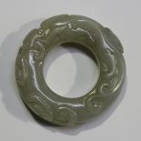 A Chinese pale celadon jade hoop-shaped pendant, probably 20th century, carved in low relief with