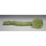 A Chinese carved celadon jade ruyi sceptre, late Qing dynasty or later, the serpentine handle carved