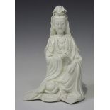 A Chinese blanc-de-Chine porcelain figure of Guanyin, Qing dynasty, modelled seated wearing a long