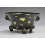 A Chinese gold splashed brown patinated bronze tripod censer, probably late Qing dynasty, the flared