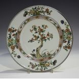 A Chinese famille verte porcelain plate, Kangxi period, the centre painted and gilt with a