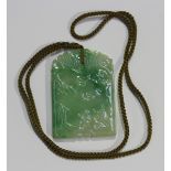 A Chinese jadeite plaque pendant, probably 20th century, of arched rectangular shape, carved in