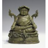 A Sino-Tibetan bronze figure of a lama, modelled seated in dhyanasana, wearing a lotus leaf hat,