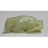 A Chinese pale celadon jade pendant, probably 20th century, carved as a recumbent horse with a