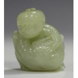 A Chinese pale celadon jade carving of a boy, probably 20th century, modelled holding a goose,