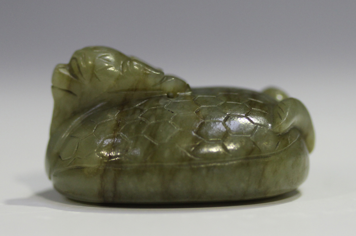 A Chinese carved celadon jade dragon pendant, 20th century, of oval shape, the stone with brown line