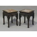 A pair of Chinese hardwood stands, late Qing dynasty, each square top inset with a rouge marble