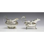 A George IV silver milk jug of half-reeded oval form with foliate capped scroll handle, London