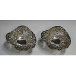 A pair of late Victorian silver heart shaped bonbon dishes, each pierced and embossed with foliate