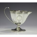 A George III silver milk jug of octagonal tapered form with bright cut engraved decoration, reeded