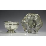 A George V silver circular sugar bowl with upright strapwork panelled decoration, on a stepped foot,