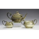 An Edwardian silver three-piece tea set, each piece of cushion form with shaped rim, comprising
