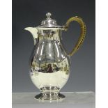 A Victorian silver hot water pot of baluster form with hinged lid and wicker mounted handle,