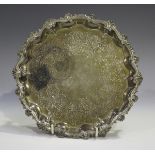 A Victorian silver salver with cast scallop and scroll rim, the centre engraved with a band of