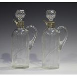 A pair of late Victorian silver mounted clear glass spirit flasks and stoppers, each cylindrical