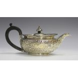 A George III silver teapot of squat circular form, later chased and engraved with foliate scrolls