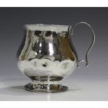 A George V silver christening cup, the baluster body with hammered decoration, flanked by a scroll