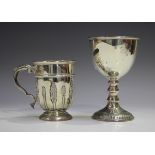 A George V silver christening cup with upright foliate panels, flanked by a foliate scroll handle,