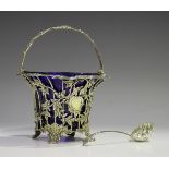 An early Victorian silver sugar basket with blue glass liner, the wirework frame applied with