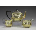 A George V silver three-piece tea set, comprising teapot, milk jug and sugar bowl, each of cushion