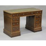 A late Victorian oak and mahogany twin-pedestal desk, the moulded top inset with a gilt-tooled green