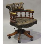 A late 20th century reproduction stained hardwood tub back revolving office chair, upholstered in
