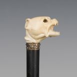 A 19th century ebonized walking cane, the ivory handle carved as a dog's head with inset glass