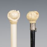 A late Victorian ebonized walking cane, the ivory handle carved as a hand holding a ball above a