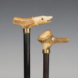 An early 20th century ebonized walking cane, the stag antler handle carved as a fish head, length