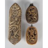 An Eastern carved bone pendant, worked in relief with a standing deity, length 12cm, two similar