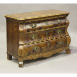 A late 20th century Louis XV style walnut bombé commode, fitted with three drawers, on scroll