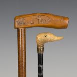 An Edwardian ebonized walking cane, the horn handle carved as the head of a bird with inset glass