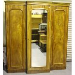 A mid-Victorian figured pale mahogany three-section wardrobe, the mirrored door enclosing sliding