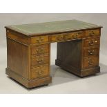 An Edwardian walnut twin-pedestal desk, the top inset with later green leather above an