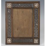 An early 20th century Middle Eastern olivewood and mother-of-pearl inlaid frame, inset with