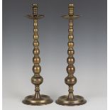 A pair of 20th century patinated brass candlesticks of turned knop form, height 54cm.Buyer’s Premium