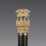 A 19th century ebonized walking cane, the ivory handle finely carved with a ring of four lions above