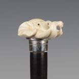 A late 19th/early 20th century ebonized walking cane, the ivory handle carved as the head of an