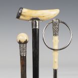 A late 19th century ebonized walking cane, the boar's tusk handle with white metal mounts, inscribed