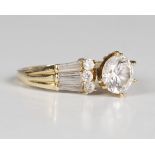 A gold and cubic zirconia ring, claw set with the principal circular cut colourless gem to the