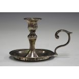A Victorian silver taper chamberstick with urn shaped nozzle and baluster stem, the circular