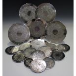 A set of six Elizabeth II silver mounted placemats and twelve matching coasters of circular form