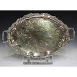 A late Victorian plated two-handled oval tray with cast foliate handles and border, framing engraved