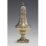 A George III silver pepper caster with pierced and engraved domed cover above a baluster body on a