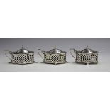 A near pair of Edwardian silver mustards, each of quatrelobed outline with pierced sides, hinged lid