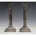 A pair of late Victorian silver Corinthian column candlesticks, each with detachable nozzle on a