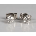 A pair of diamond single stone earstuds, each claw set with a circular cut diamond, with post and