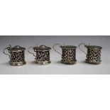 A near pair of George V silver cylindrical mustards, each with pierced decoration, hinged lid and